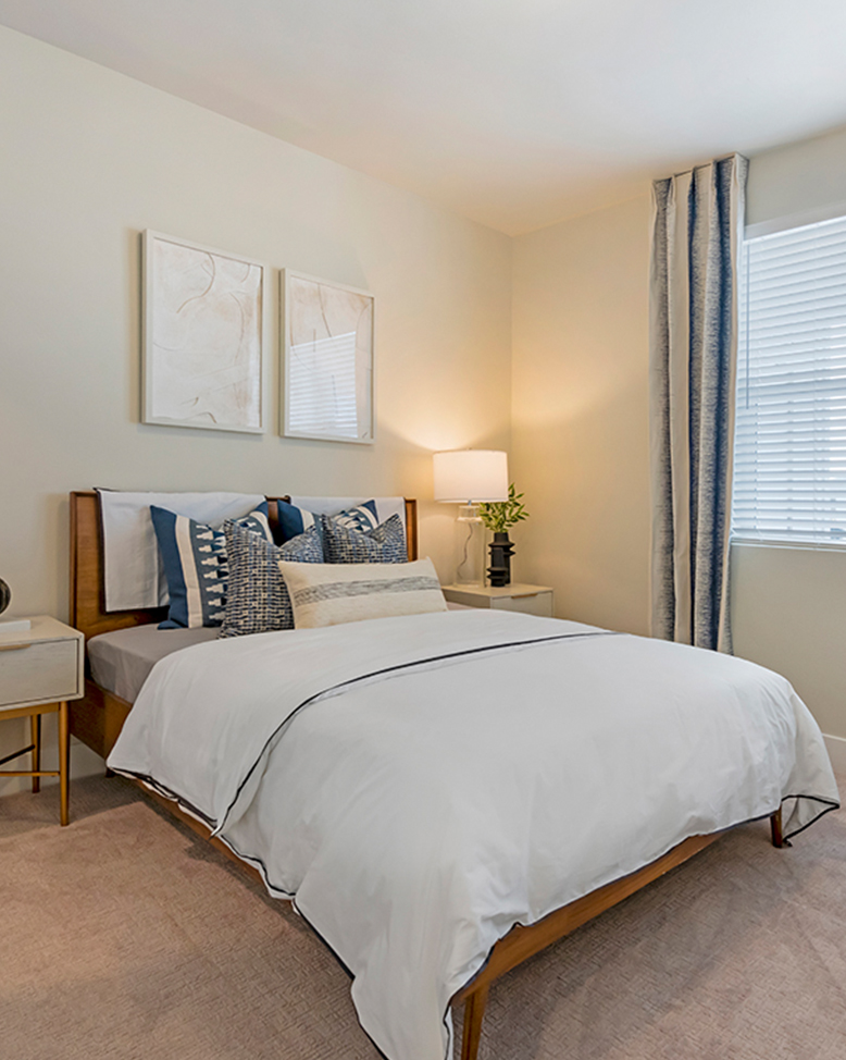 Bedroom with artwork, a large window, and carpet.